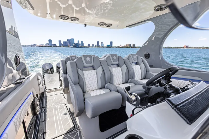 Slide: The Image of Luxurious 2026 Mystic Powerboats M4200 interior with plush seating and city skyline view. - 33
