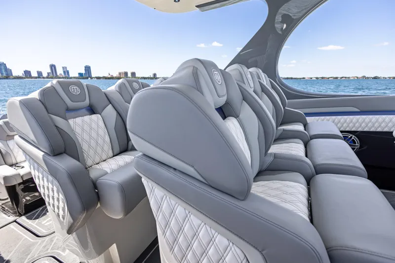 Slide: The Image of Luxurious seating on 2026 Mystic Powerboats M4200, with city skyline and ocean view. - 34