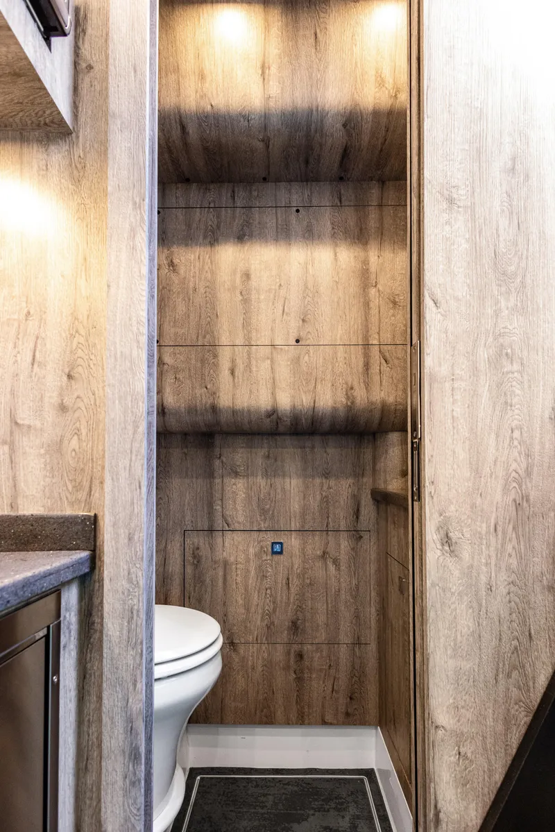 Slide: The Image of Interior of 2026 Mystic Powerboats M4200, featuring a modern wooden-finish bathroom with toilet. - 4