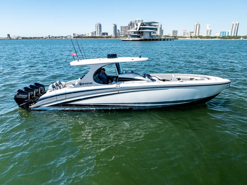 Slide: The Image of 2026 Mystic Powerboats M4200 cruising on water with city skyline in background. - 42