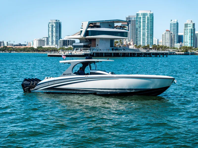 Slide: The Image of 2026 Mystic Powerboats M4200 cruising on water with city skyline in background. - 47