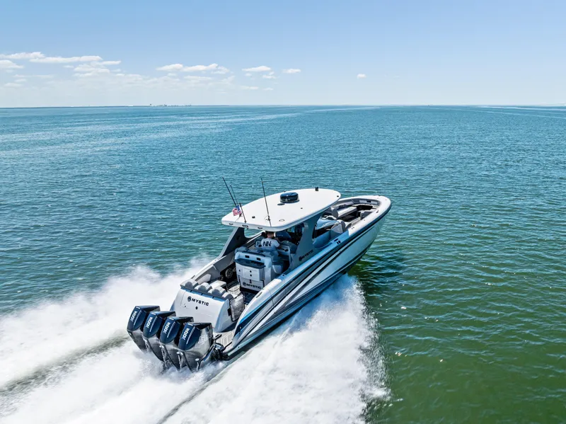 Slide: The Image of 2026 Mystic Powerboats M4200 speeding on open water under clear skies. - 48