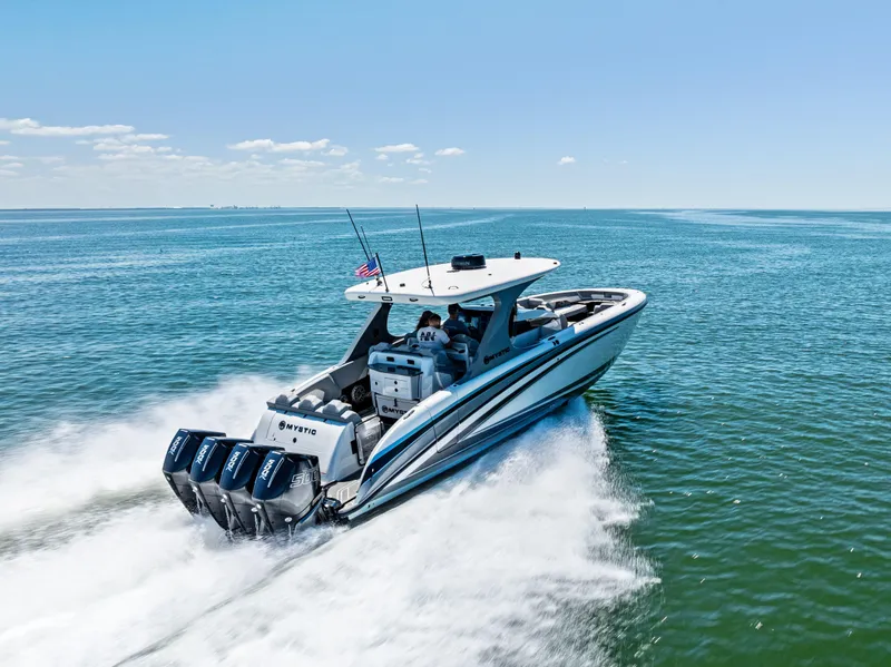 Slide: The Image of 2026 Mystic Powerboats M4200 speeding on open water under clear blue skies. - 49