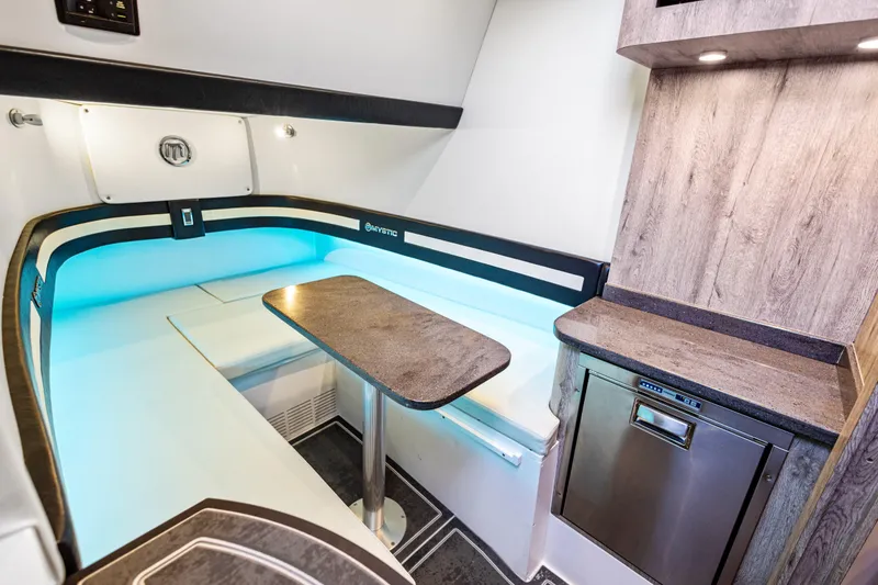 Slide: The Image of 2026 Mystic Powerboats M4200 interior with modern seating, table, and kitchenette. - 8