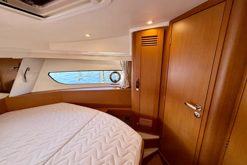 Slide: The Image of 2026 Beneteau Swift Trawler 37 Fly cabin interior with wooden finish and cozy bed. - 14
