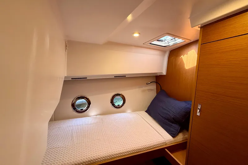 Slide: The Image of Cozy cabin interior of 2026 Beneteau Swift Trawler 37 Fly with portholes and bedding. - 16