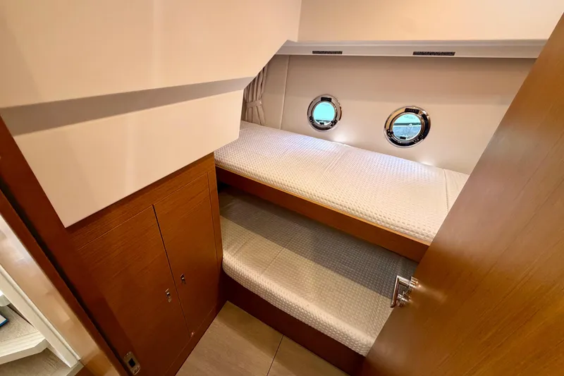 Slide: The Image of Interior of 2026 Beneteau Swift Trawler 37 Fly with bunk beds and portholes. - 17