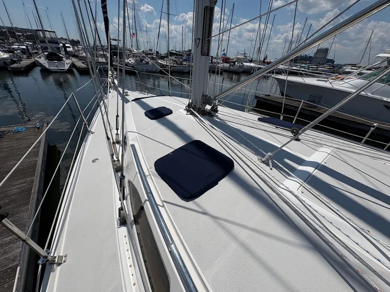 Slide: The Image of 2006 Catalina 350 sailboat docked at marina, surrounded by other boats under a partly cloudy sky. - 13