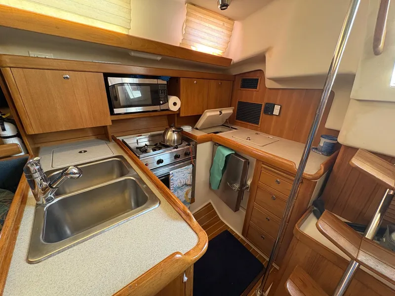 Slide: The Image of Interior of 2006 Catalina 350 sailboat kitchen with sink, stove, and microwave. - 23
