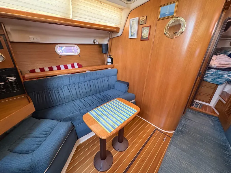 Slide: The Image of Interior of a 2006 Catalina 350 sailboat with blue seating and wooden accents. - 25