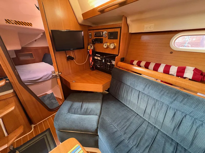 Slide: The Image of Interior of a 2006 Catalina 350 sailboat with cozy seating and navigation equipment. - 26