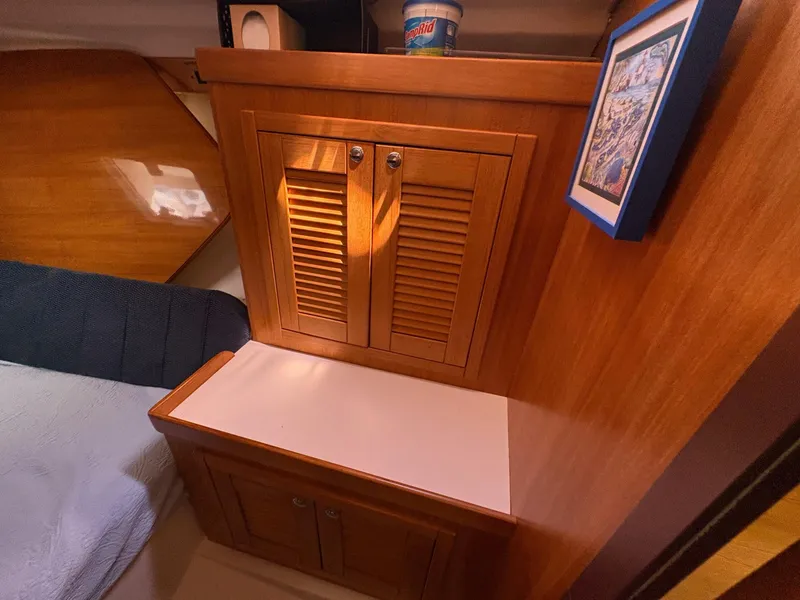 Slide: The Image of Wooden interior of a 2006 Catalina 350 sailboat with cabinets and framed artwork. - 28