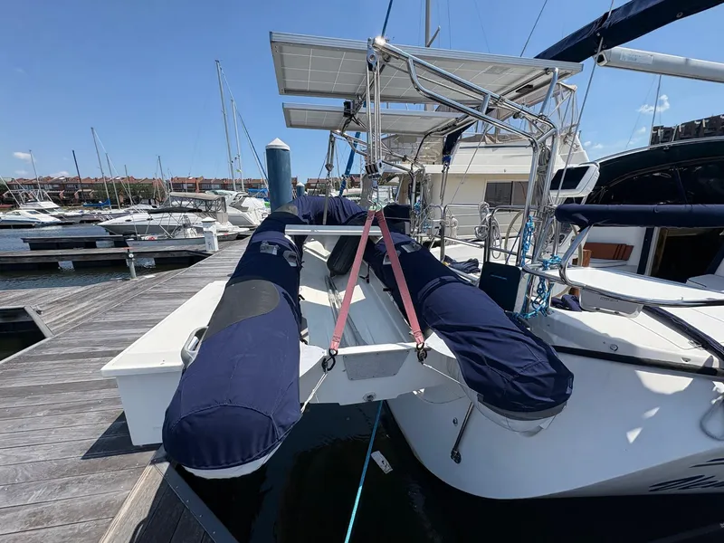 Slide: The Image of Catalina 350 sailboat docked, featuring solar panels and covered equipment, 2006 model. - 3