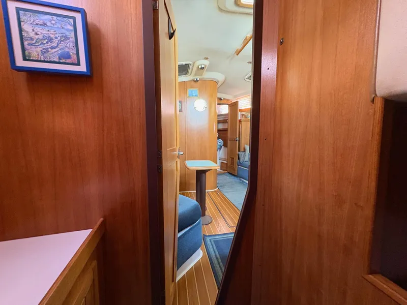Slide: The Image of Interior of a 2006 Catalina 350 sailboat, featuring wooden paneling and cozy seating. - 31