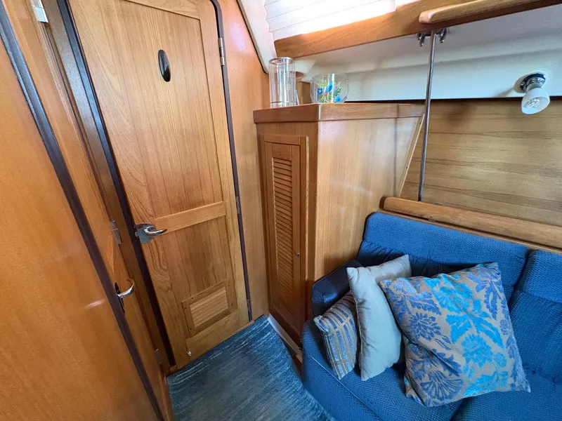Slide: The Image of Interior of 2006 Catalina 350 sailboat with wooden cabinetry and blue cushioned seating. - 33