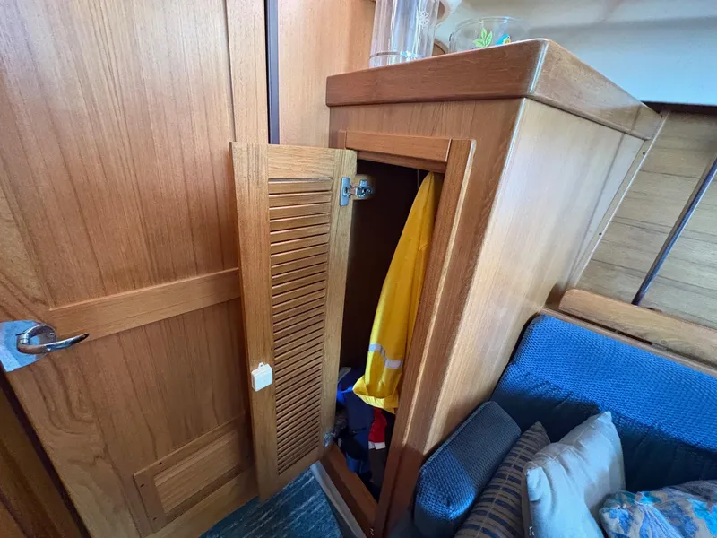 Slide: The Image of Wooden interior of a 2006 Catalina 350 sailboat with open storage cabinet. - 34