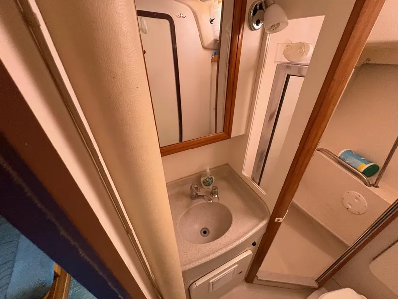 Slide: The Image of Bathroom interior of a 2006 Catalina 350 sailboat, featuring a compact sink and mirror. - 36