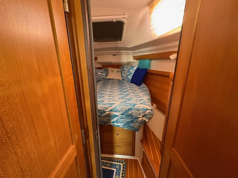 Slide: The Image of Cozy cabin interior of 2006 Catalina 350 sailboat with wooden finish and nautical bedding. - 38