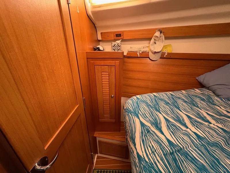 Slide: The Image of Cozy cabin interior of 2006 Catalina 350 sailboat with wooden cabinetry and patterned bedding. - 41