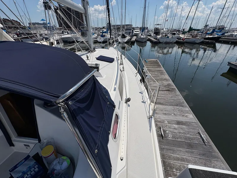 Slide: The Image of 2006 Catalina 350 sailboat docked at marina, surrounded by other boats under a clear sky. - 45