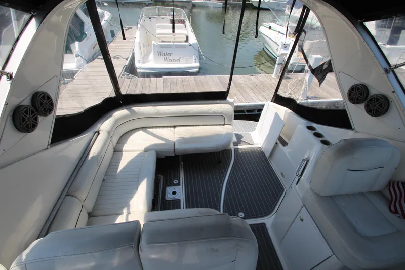 Slide: The Image of Interior view of 1999 Bayliner 3055 Ciera yacht with white seating and docked boats outside. - 13