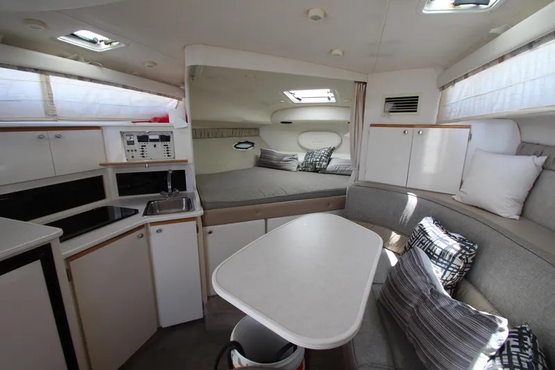 Slide: The Image of 1999 Bayliner 3055 Ciera cabin interior with kitchenette, seating, and sleeping area. - 17