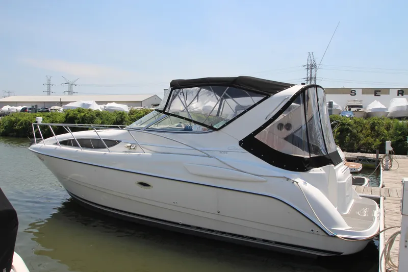Slide: The Image of 1999 Bayliner 3055 Ciera boat docked at marina, featuring sleek design and covered cockpit. - 2