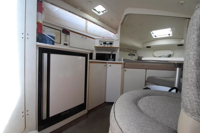 Slide: The Image of Interior of 1999 Bayliner 3055 Ciera boat, featuring kitchenette and seating area. - 23