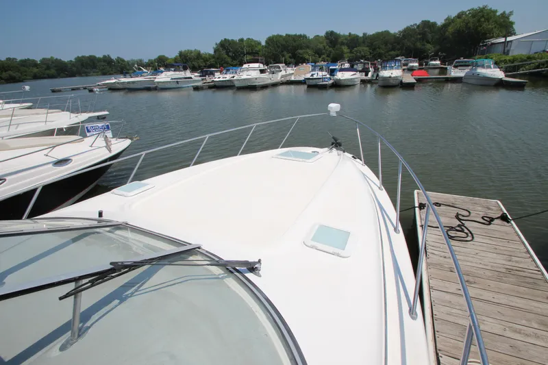 Slide: The Image of 1999 Bayliner 3055 Ciera docked at marina, surrounded by other boats on a sunny day. - 3
