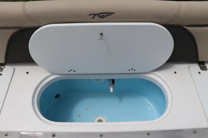 Slide: The Image of Livewell compartment on a 2022 Tidewater 232 SS boat, featuring a blue interior. - 10