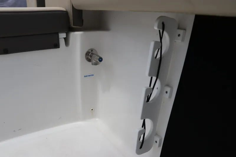 Slide: The Image of 2022 Tidewater 232 SS boat interior showing raw water outlet and cable holders. - 13