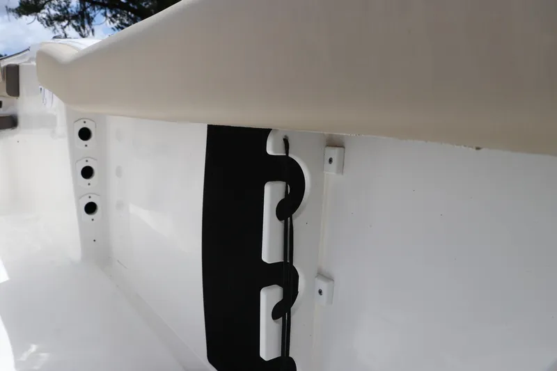 Slide: The Image of 2022 Tidewater 232 SS boat interior detail with rod holders and storage. - 14