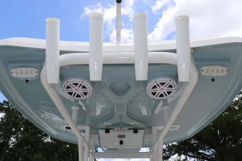 Slide: The Image of 2022 Tidewater 232 SS boat T-top with rod holders and speakers against blue sky. - 18