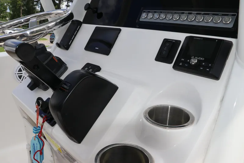 Slide: The Image of 2022 Tidewater 232 SS boat console with steering wheel, controls, and audio system. - 23