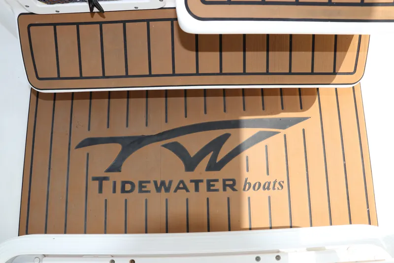 Slide: The Image of Tidewater 232 SS 2022 boat deck with logo and wood-style finish. - 26