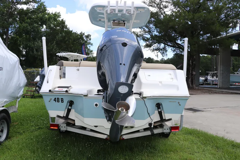 Slide: The Image of 2022 Tidewater 232 SS boat with outboard motor, parked on grass. - 3
