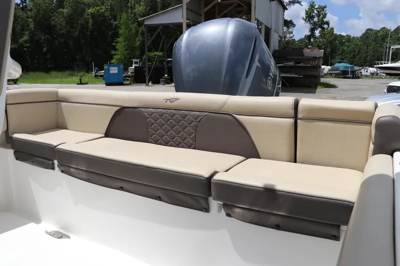 Slide: The Image of 2022 Tidewater 232 SS boat interior with beige and brown cushioned seating. - 5