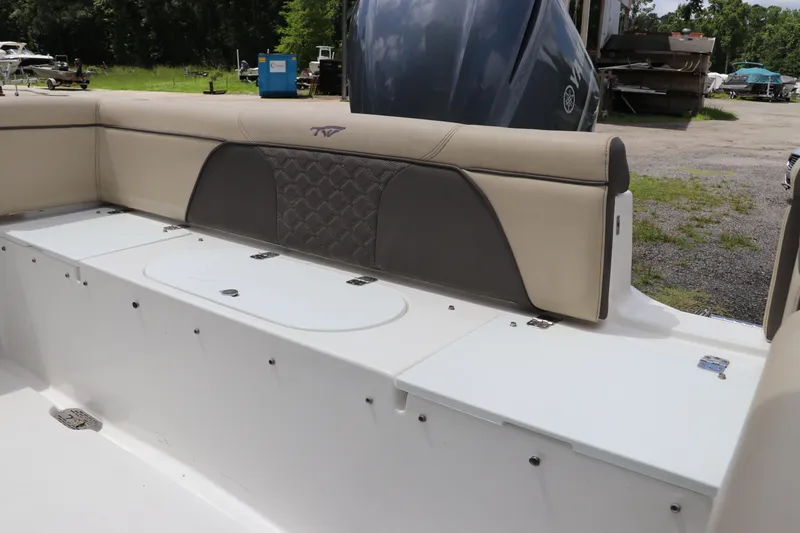 Slide: The Image of 2022 Tidewater 232 SS boat interior with beige seating and storage compartments. - 6