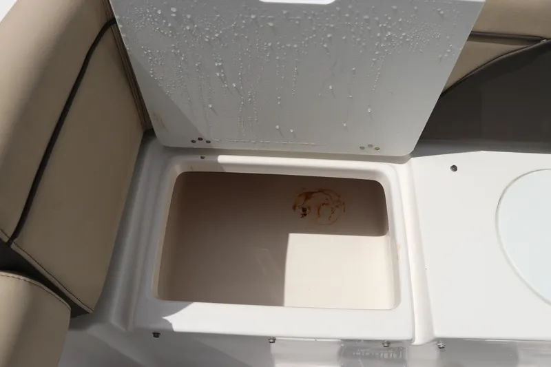 Slide: The Image of Open storage compartment on 2022 Tidewater 232 SS boat, featuring beige seating. - 8