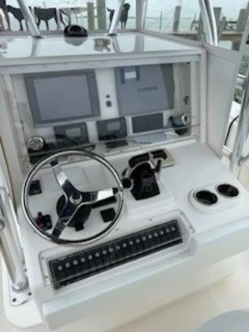 Slide: The Image of 2012 Invincible 36 Open Fisherman boat dashboard with steering wheel and navigation controls. - 8