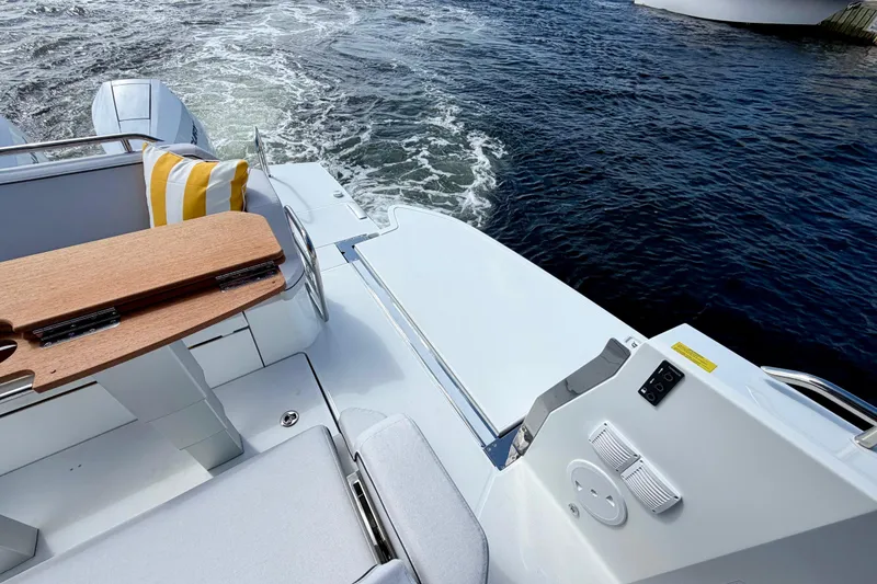 Slide: The Image of 2026 Beneteau Gran Turismo 35 yacht deck with wooden table and striped cushion. - 15