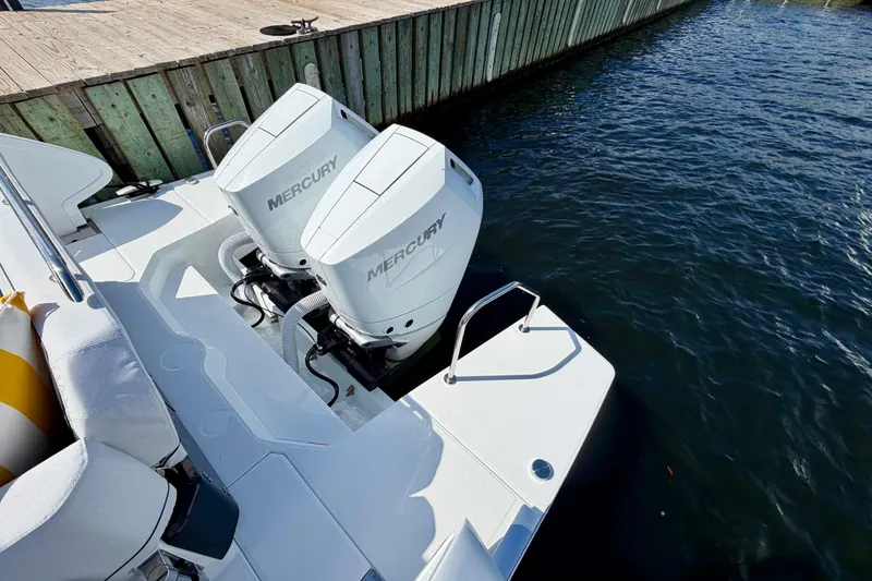 Slide: The Image of 2026 Beneteau Gran Turismo 35 with twin Mercury outboard engines docked by wooden pier. - 18