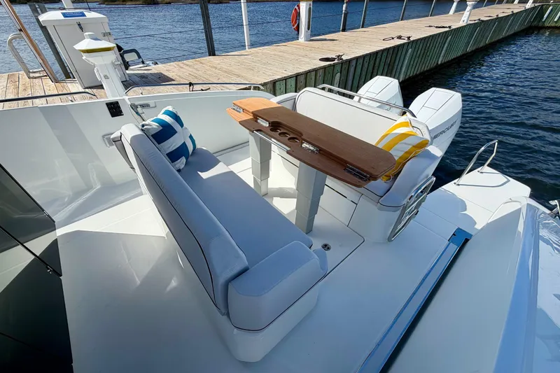 Slide: The Image of 2026 Beneteau Gran Turismo 35 yacht interior with seating and table, docked by the water. - 25