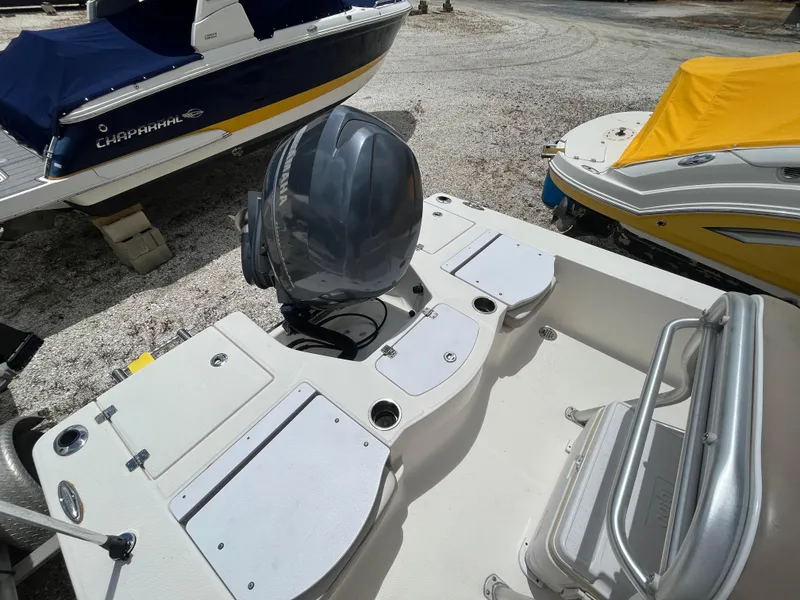 Slide: The Image of 2016 Robalo 206 Cayman boat with Yamaha outboard motor, docked near other covered boats. - 11