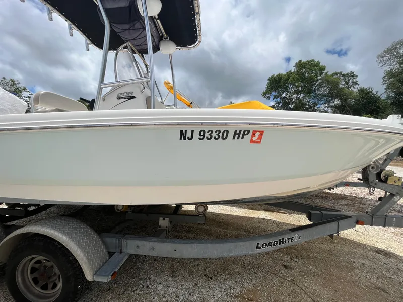 Slide: The Image of 2016 Robalo 206 Cayman boat on trailer, registration NJ 9330 HP, under cloudy sky. - 12
