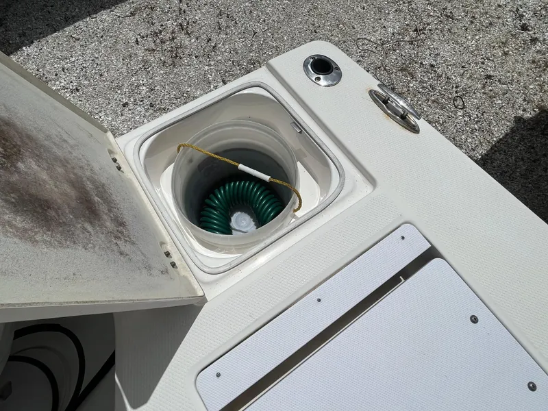 Slide: The Image of Open storage compartment on 2016 Robalo 206 Cayman boat with coiled green hose. - 14