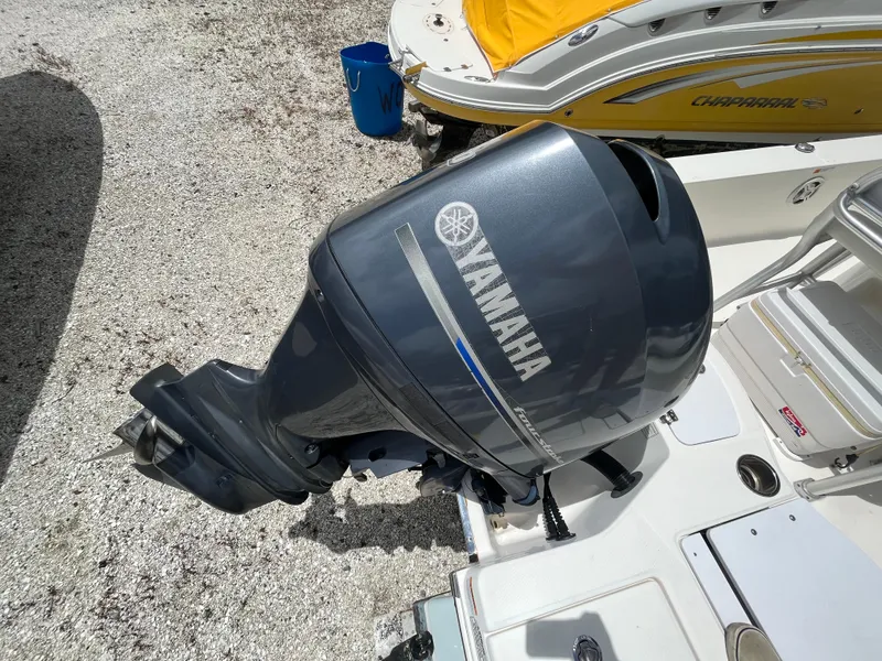 Slide: The Image of 2016 Robalo 206 Cayman with Yamaha outboard motor, parked on gravel. - 16