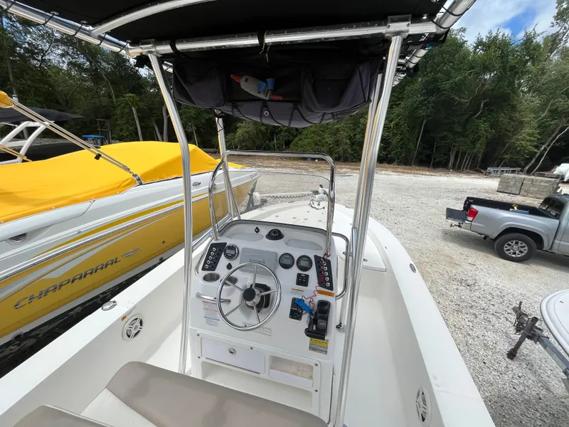 Slide: The Image of 2016 Robalo 206 Cayman boat dashboard with steering wheel and controls, parked near other boats. - 21