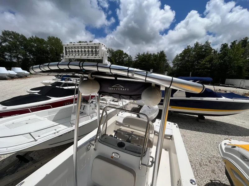 Slide: The Image of 2016 Robalo 206 Cayman boat with T-top and LED lights, parked outdoors under cloudy sky. - 29