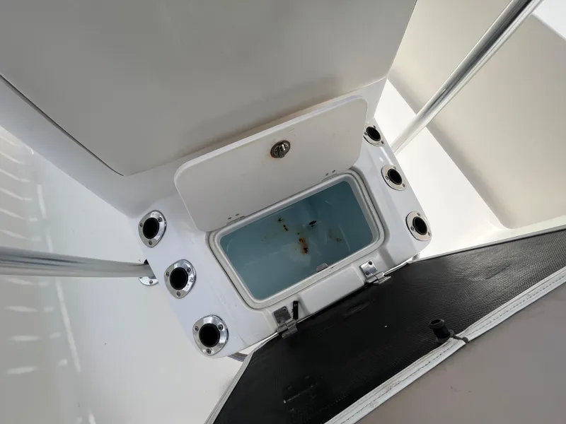 Slide: The Image of 2016 Robalo 206 Cayman boat storage compartment with rod holders, open lid view. - 31
